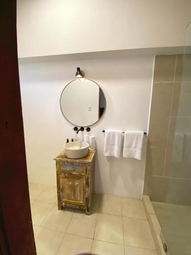 a bathroom with a sink and a mirror and towels at Mestizo Antigua Cortijo in Ciudad Vieja