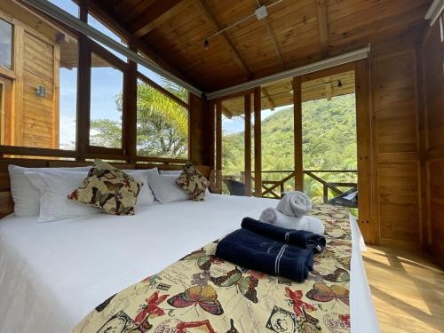 a bedroom with a bed in a room with windows at Home Boutique Natural Paradise in La Vega