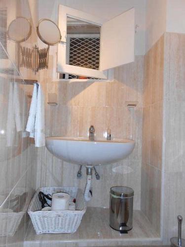 łazienka z umywalką i koszem na śmieci w obiekcie Piazzetta Scolanova w mieście Trani