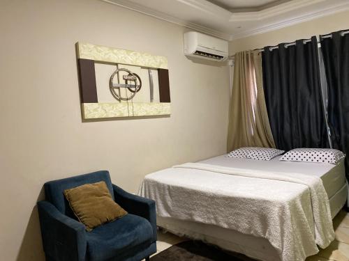 um quarto com uma cama e uma cadeira azul em Pousada Paisagem em Jaraguá do Sul