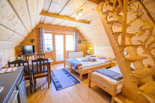 una sala de estar con una escalera en una cabaña de madera en Sopalowka en Kościelisko