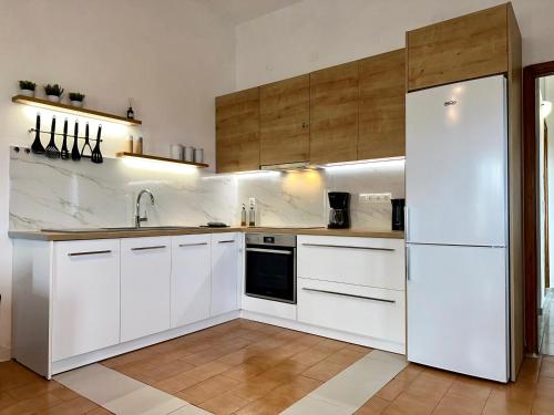 a kitchen with white cabinets and a refrigerator at Romanza Kournás in Kournás