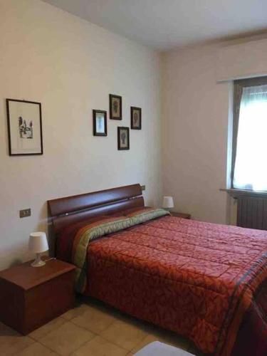 a bedroom with a bed and pictures on the wall at Il relax tra mare e campagna in Castiglione della Pescaia