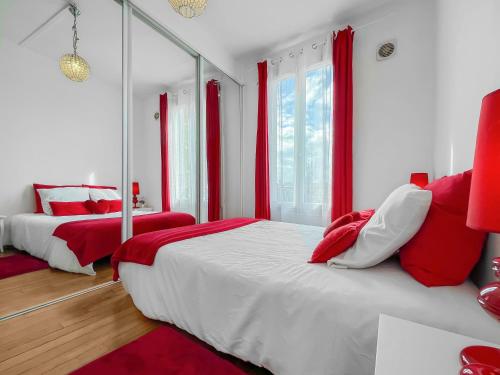 um quarto com 2 camas com almofadas vermelhas e brancas em Porte de Paris Élégance à Vitry-sur-Seine em Vitry-sur-Seine