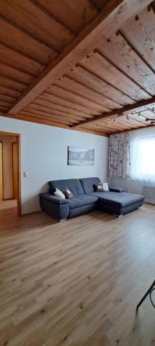 Winzerhof Supperer في Rossatz: غرفة معيشة مع أرائك زرقاء وسقف خشبي