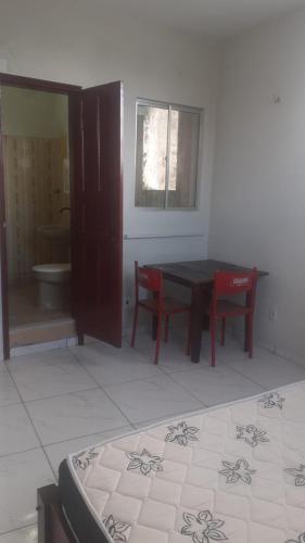 a room with a table and two chairs and a bathroom at Carpe Diem Suítes in Belém