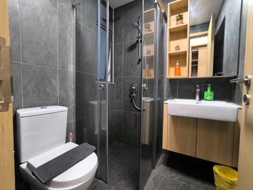 uma casa de banho com um chuveiro, um WC e um lavatório. em The Luxe Suites KLCC by Cozy Stay em Kuala Lumpur