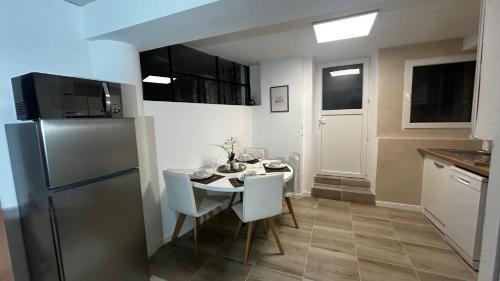 une cuisine avec une table avec des chaises et un réfrigérateur dans l'établissement PRIMO - Logement 4personnes, à Braux