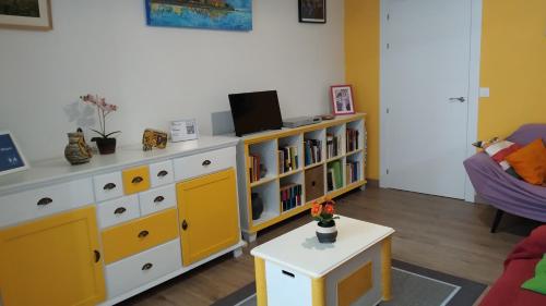una sala de estar con una cómoda de color amarillo y blanco en Apto Cimavilla Santa Cándida junto Plaza Mayor VUT-114-AS, en Gijón