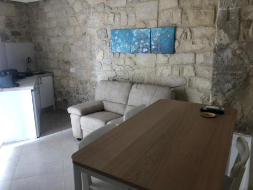 a living room with a wooden table and a couch at Mastranza 20 in Scicli
