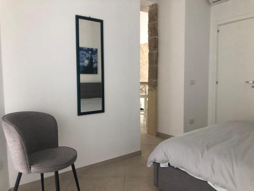 a bedroom with a chair and a mirror on the wall at Mastranza 20 in Scicli