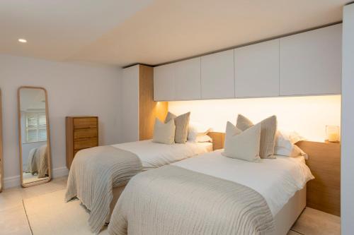 a bedroom with two beds and a mirror at Kist Accommodates - The Stray Nook in Harrogate