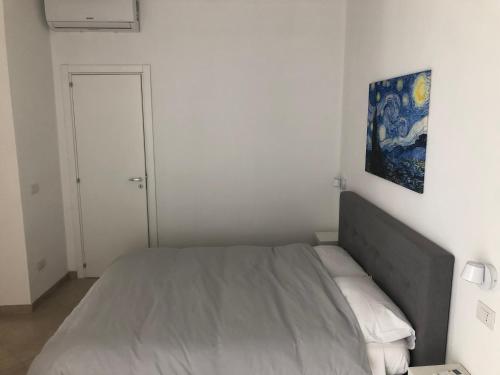 a bedroom with a bed with a painting on the wall at Mastranza 20 in Scicli