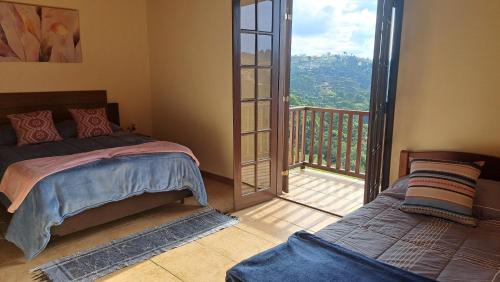 a bedroom with a bed and a balcony at Casa Sossego na Montanha in Campos do Jordão