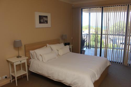 ein Schlafzimmer mit großem Bett und Balkon in der Unterkunft The Lighthouse - Beachfront Accommodation in Port Hughes