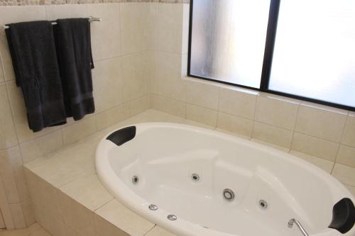 baño con bañera blanca y ventana en The Lighthouse - Beachfront Accommodation, en Port Hughes