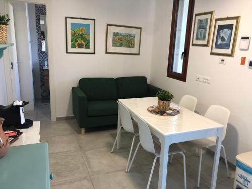a living room with a table and a green couch at BREZZA DI LEVANTE in Cefalù