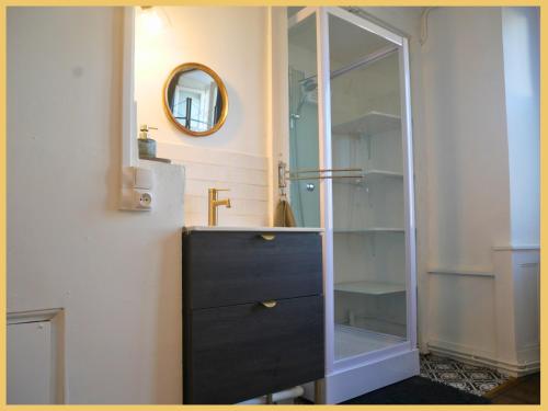 łazienka z czarną komodą i lustrem w obiekcie Les Suites de Bellac w mieście Bellac