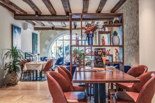 - une salle à manger avec une table et des chaises dans l'établissement The Originals Boutique, Hôtel Le George , Loches, à Loches