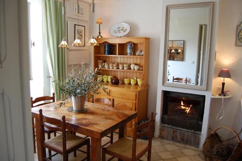 a dining room with a table and a fireplace at Ma Maison sur la Colline in Escosse