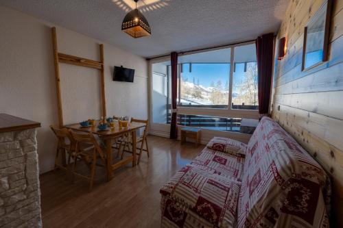 a living room with a table and a room with a view at Doux Crépuscule - Départ Randonnée & VTT - Parking in Enchastrayes