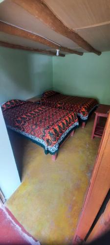 a bed in the corner of a room at Hospedaje Wayna Pakaq in Huanipaca