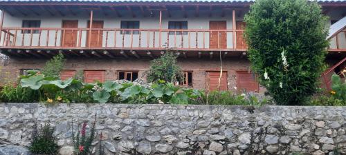 ein Haus mit einer Steinmauer mit Pflanzen davor in der Unterkunft Hospedaje Wayna Pakaq in Huanipaca