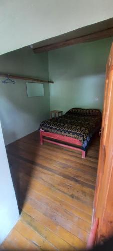 a bed in a room with a wooden floor at Hospedaje Wayna Pakaq in Huanipaca