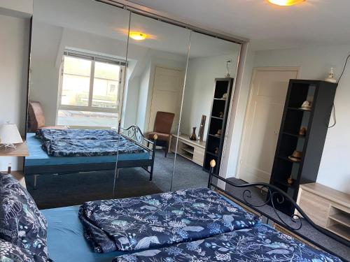 a bedroom with two beds and a mirror at Appartement Twins in Wijk aan Zee