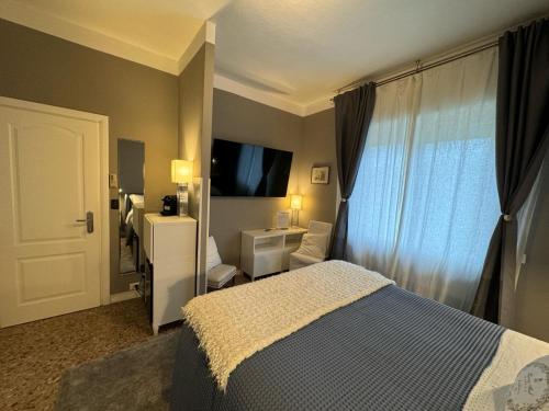 a bedroom with a bed and a window with a television at Ca' Du Ale in Sestri Levante