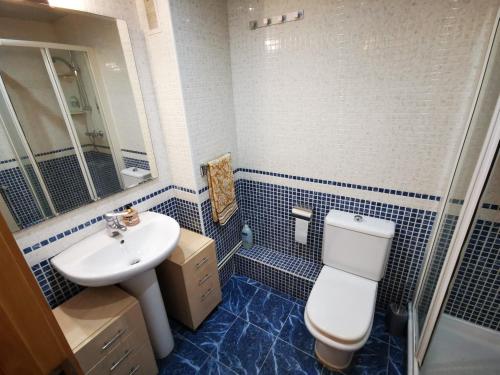 een badkamer met een wastafel, een toilet en een spiegel bij Elsi's place in Premiá de Mar