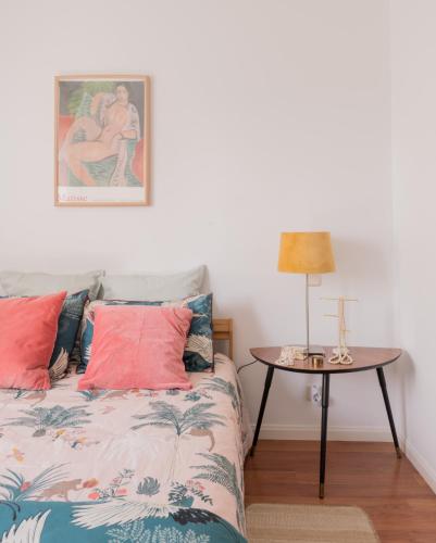 a bedroom with a bed and a table with a lamp at Cozy and Stylish Room with Natural Light and Vibrant Decor in Madrid