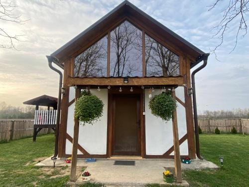 a tiny house in a yard with a porch at Zasavčanka in Sremska Mitrovica