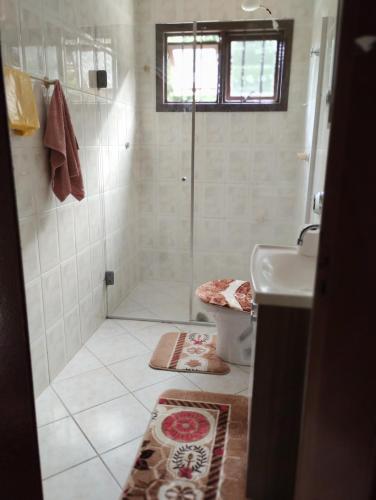 a bathroom with a shower and a toilet and a sink at Hostel de Gaia in Santa Cruz do Sul