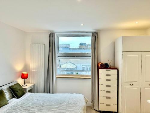 Schlafzimmer mit einem Bett und einem Fenster in der Unterkunft Large En-Suite Studio with private bath and kitchen In Canary Wharf 4 in London