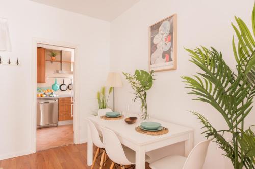 a white dining room with a white table and chairs at Cozy and Stylish Room with Natural Light and Vibrant Decor in Madrid