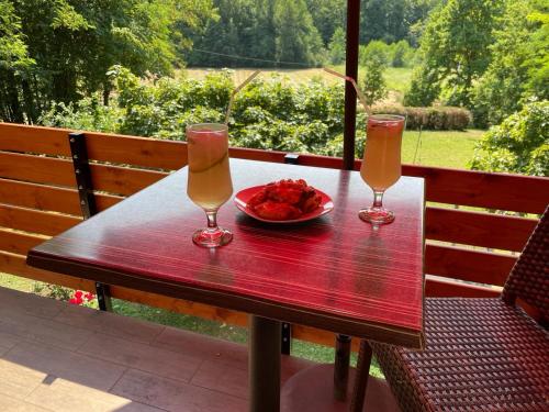 a table with two glasses and a plate of food at Vrata Plešivice in Prhoč