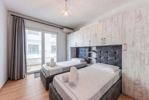 a bedroom with two beds and a large window at Seaview Luxury Suite by PS in Golem