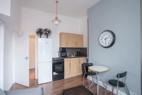 ロンドンにある2 Bedroom apartment in Central Londonのキッチン(テーブル、壁掛け時計付)