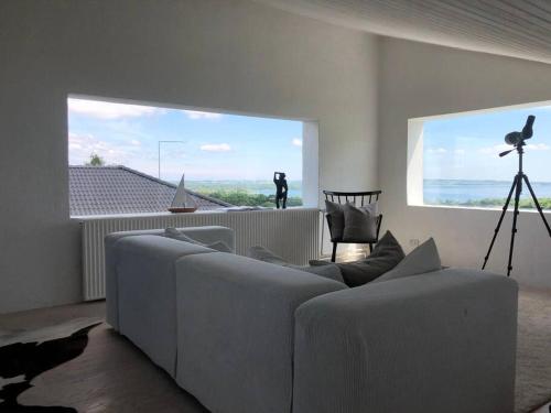 a living room with a couch and a large window at Luxury house with breathtaking sea view of Mols in Rønde
