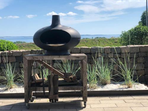 a black pot sitting on top of a wooden table at Luxury house with breathtaking sea view of Mols in Rønde