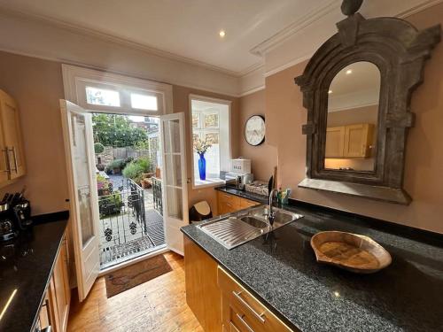 a kitchen with a sink and a large mirror at Seaside Holiday Home, Ramsgate, Latimer House in Ramsgate