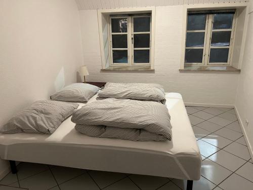 uma cama com três almofadas num quarto em Apartment with Wifi, close to city center, Beach and forrest em Aabenraa
