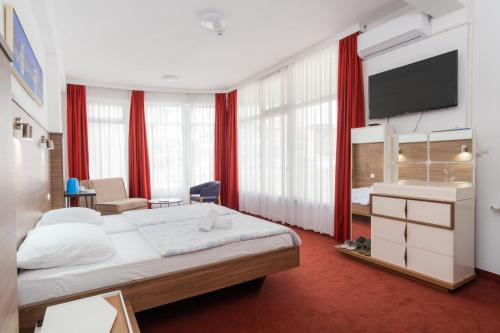 a bedroom with a large bed with red curtains at Soba Kašmir in Bugojno