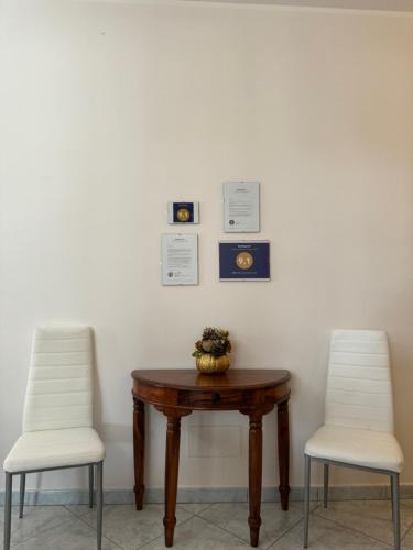 two chairs and a table with a vase on it at B&B Rose Antiche Sicily in Partinico