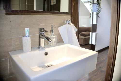 塞拉耶佛的住宿－Sarajevo Sky Suite，浴室设有白色水槽和镜子