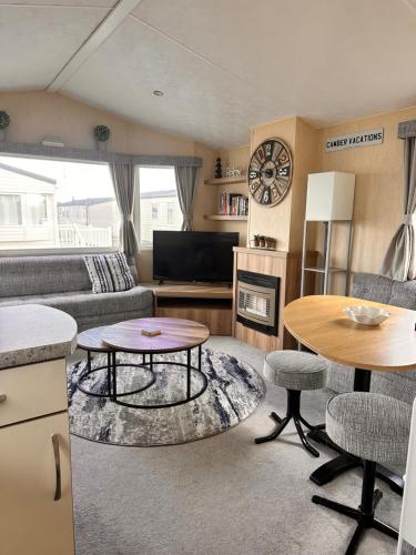 a living room with a couch and a table at Camber Vacations in Camber