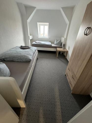 a attic bedroom with two beds and a window at Tränental DG 1 in Staßfurt