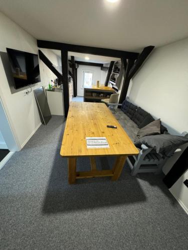 Zimmer mit einem Holztisch und einem Sofa in der Unterkunft Tränental DG 1 in Staßfurt