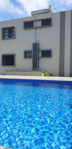 a large blue swimming pool in front of a building at ANILLAH APPARTMENTS in Centre de Flacq
